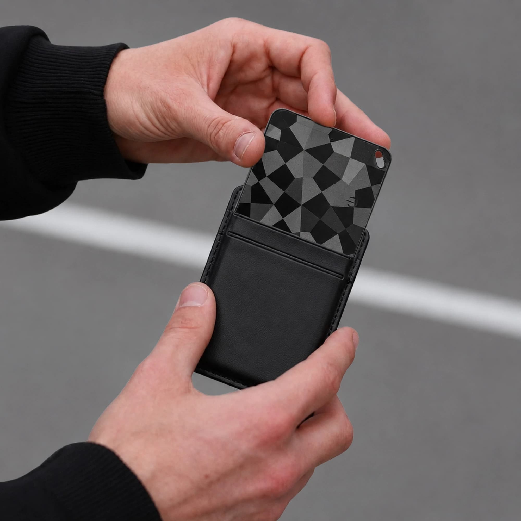 Lifestyle listing — card tracker sliding from a leather wallet